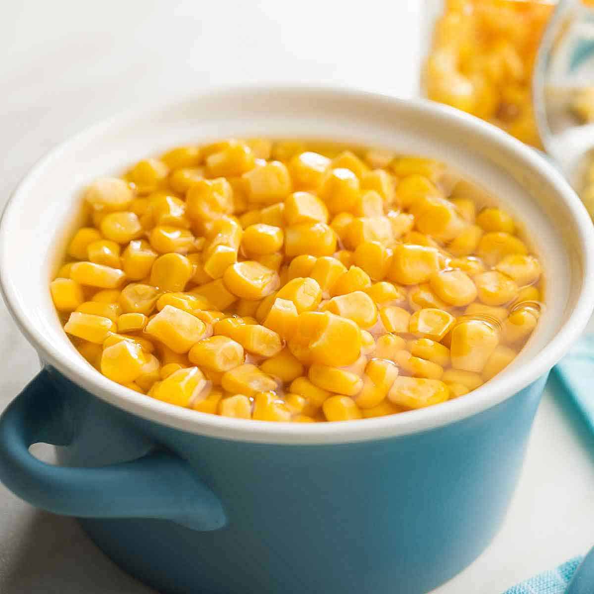 A blue bowl filled with corn kernels.