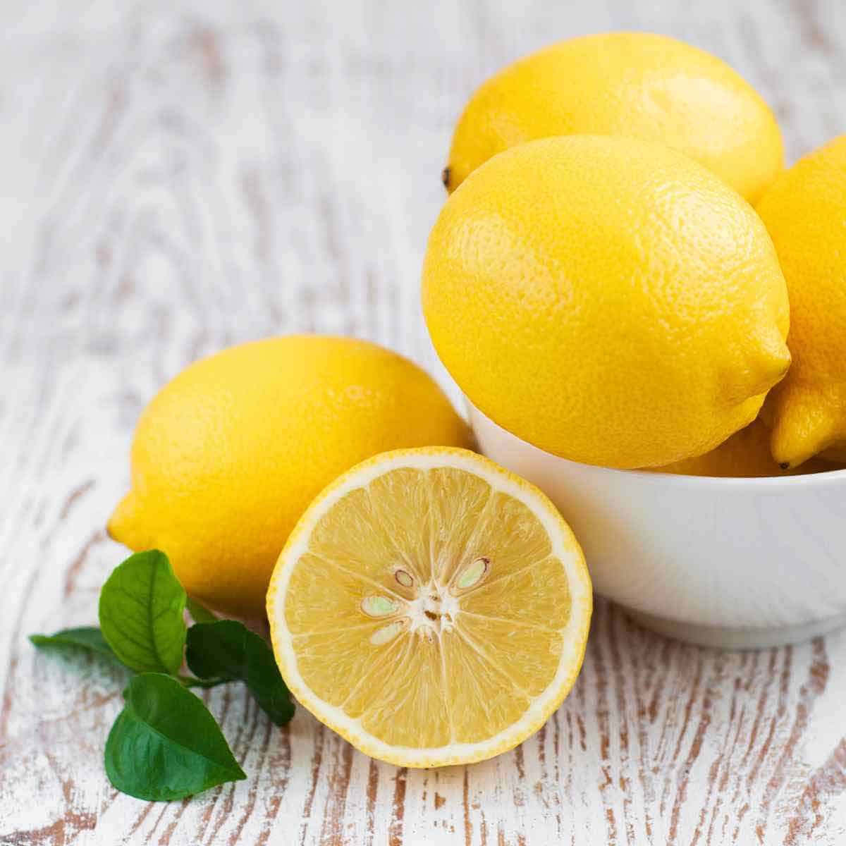 Fresh lemons in a white bowl.