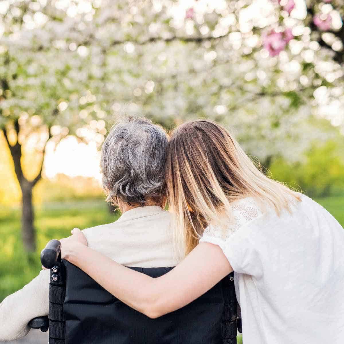 A young woman embracing an elderly woman.