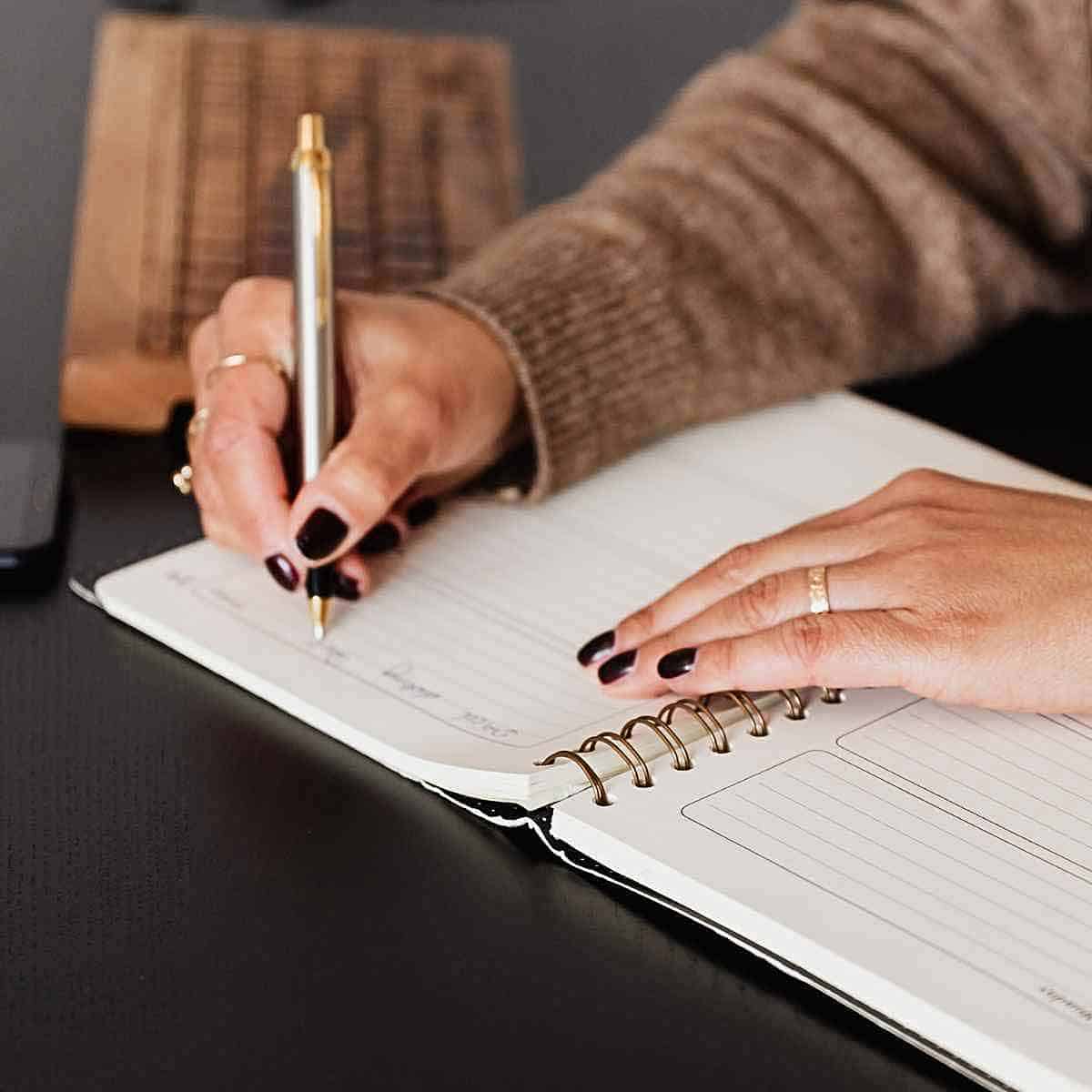 A woman writing in a gratitude journal