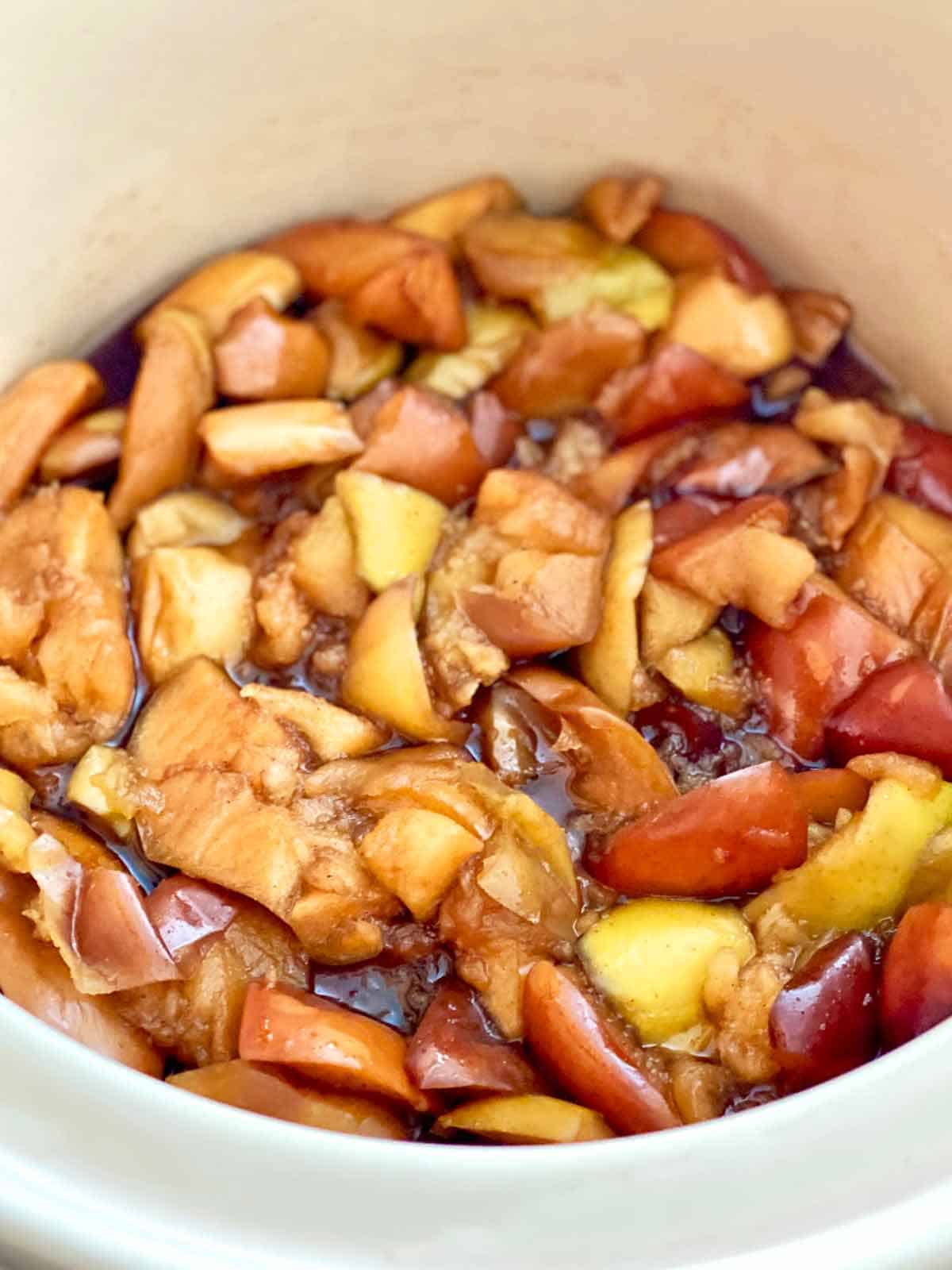 Cooked apples and spices in a crock pot, ready to be pureed for apple butter.
