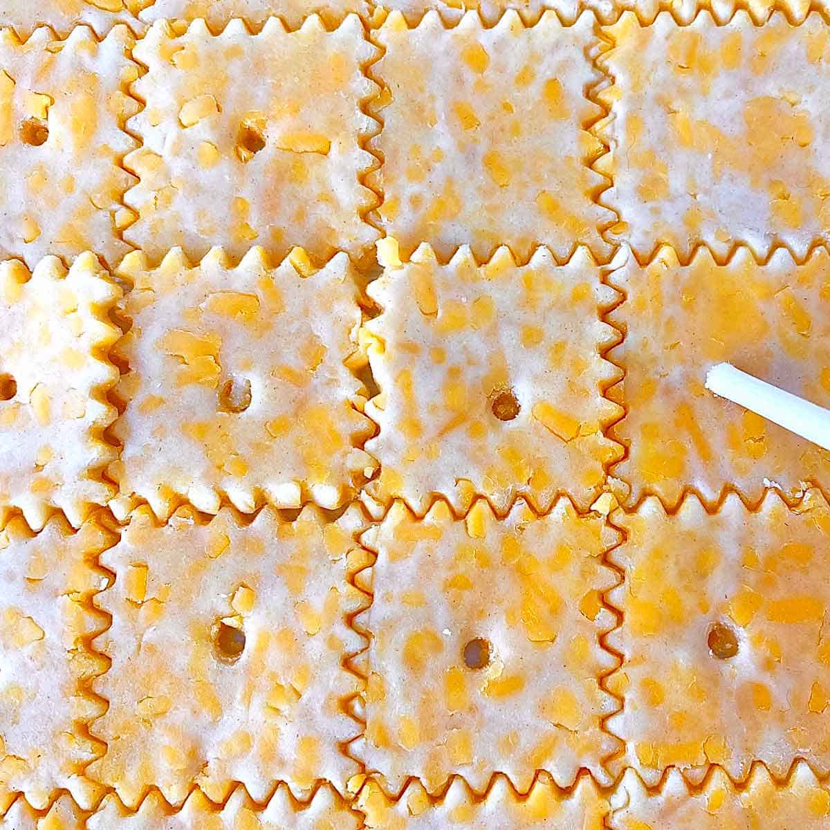 Crackers10 Poking holes with a skewer in cut cheese crackers dough.