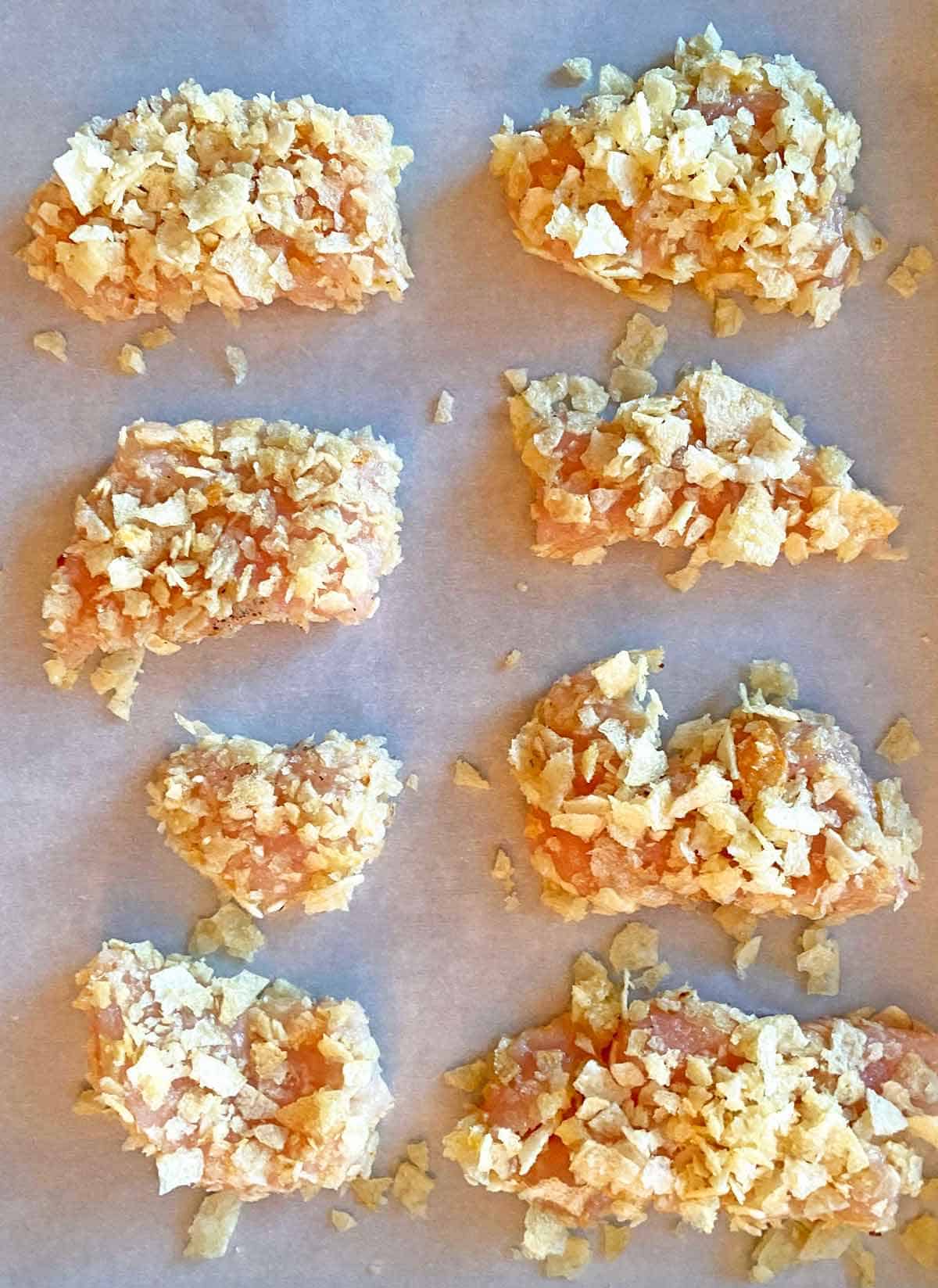 Close up of potato chip coated chicken breast strips.