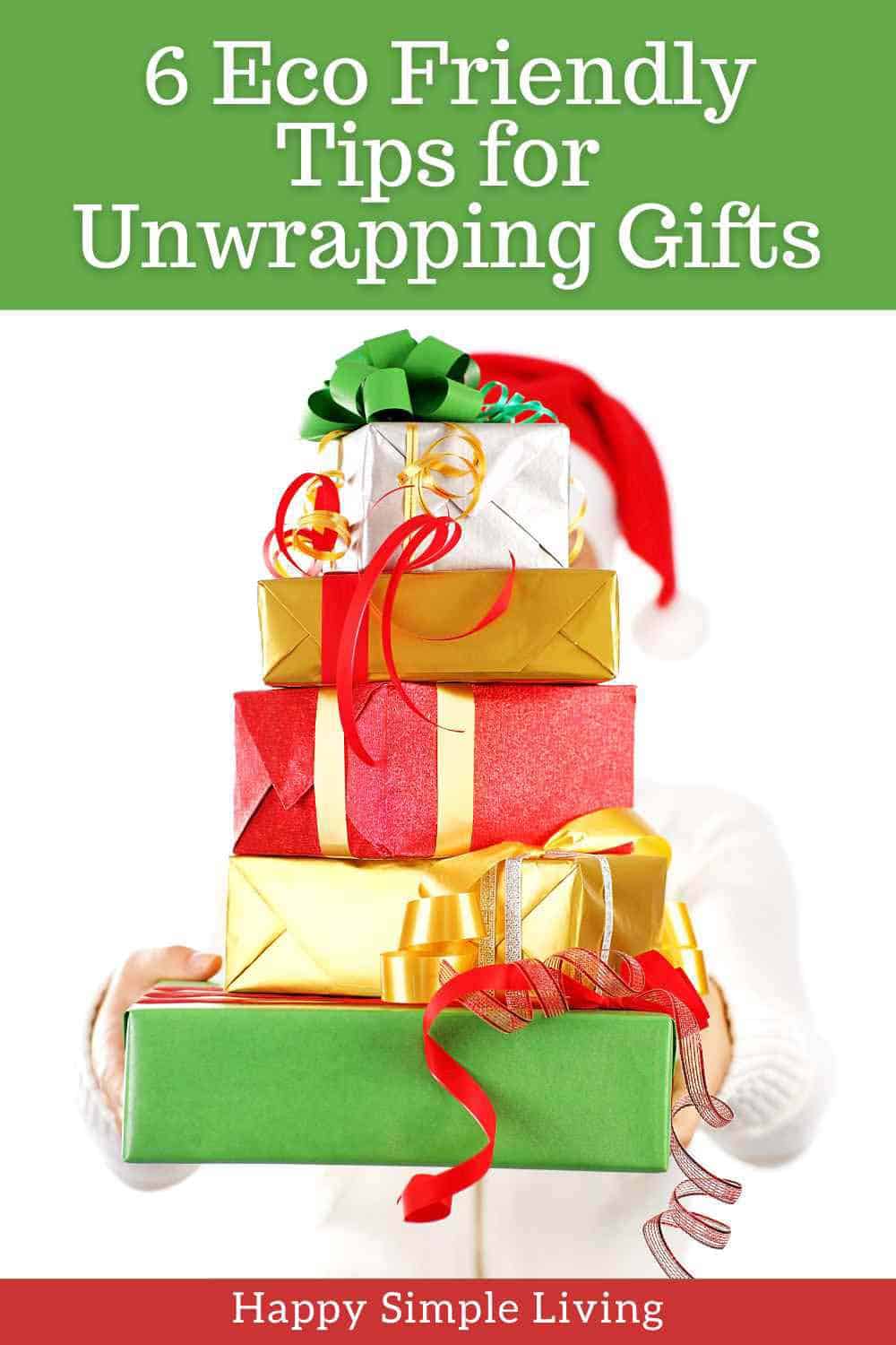 A person in a Santa hat holding a stack of wrapped presents.