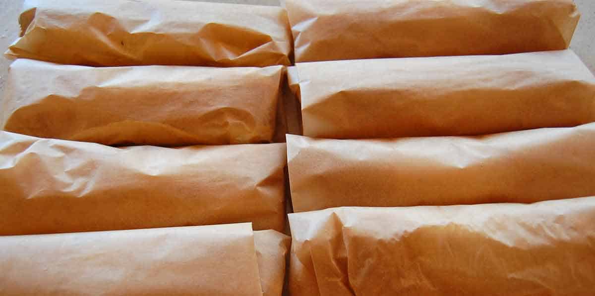 burrito6 Eight prepared breakfast burritos wrapped in parchment paper.